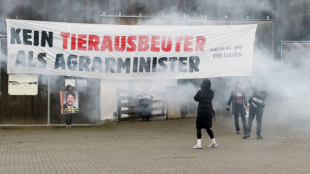 Mitglieder der Protestgruppierung Animal Rebellion halten Schilder mit Portraits vom Präsidenten des Bayerischen Bauernverbandes Felßner in die Höhe. | Bildquelle: dpa-Bildfunk
