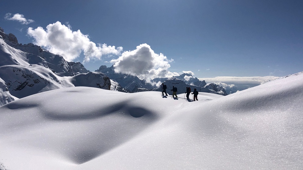 Gruppe von Tourengehern in tief verschneiter Berglandschaft | Bildquelle: BR/Kathrin Denk 
