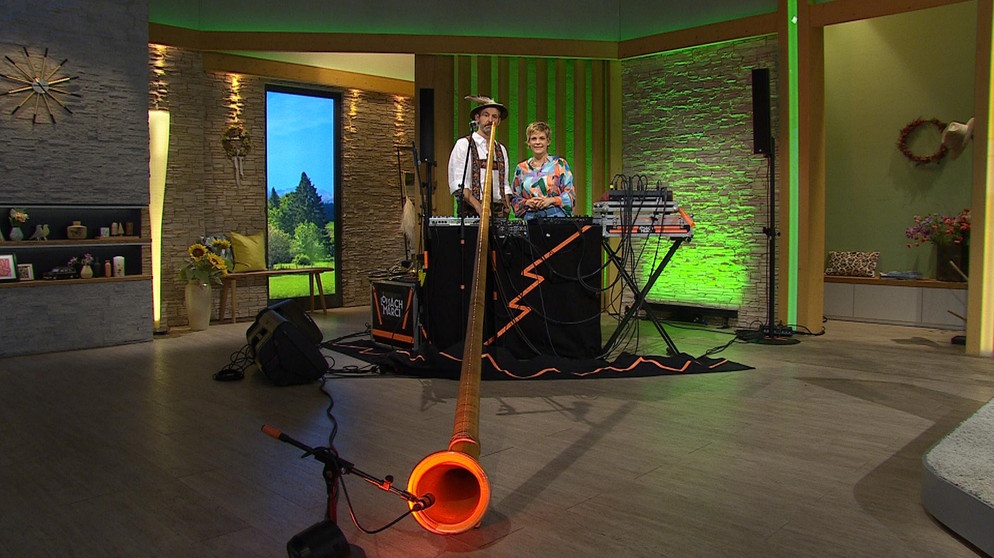 Sendungsbild vom 04.09.2023: Alphorn-Spieler Marcel Engler und Moderatorin Sandra Bouscarrut | Bildquelle: BR