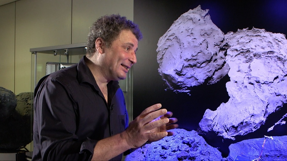 Christian Krause vom Kontrollzentrum der Mascot-Mission vor dem Bild eines Asteroiden, auf dem der Vorgänger-Lander Philae landete. | Bildquelle: BR / Maximilian Schecker