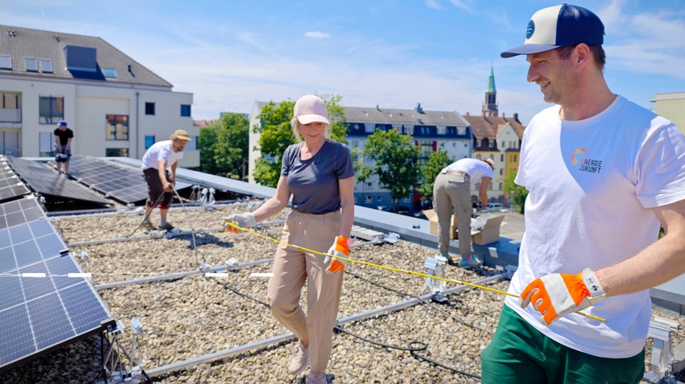 Mieter eines Mehrfamilienhauses in Nürnberg installieren eine PV-Anlage auf dem Dach des Hauses. | Bildquelle: BR/Marina Braun