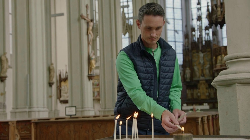STATIONEN-Moderator Benedikt Schregle zündet in einer Kirche eine Kerze an | Bildquelle: BR