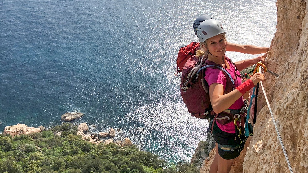 Eine Kletterin an einer Steilwand hoch über dem Meer | Bildquelle: BR/Michael Düchs