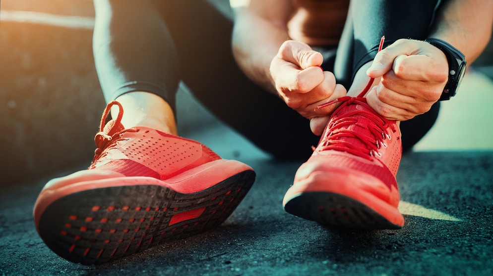 Ein Mann bindet seine Sportschuh zu. | Bildquelle: stock.adobe.com/ivanko80