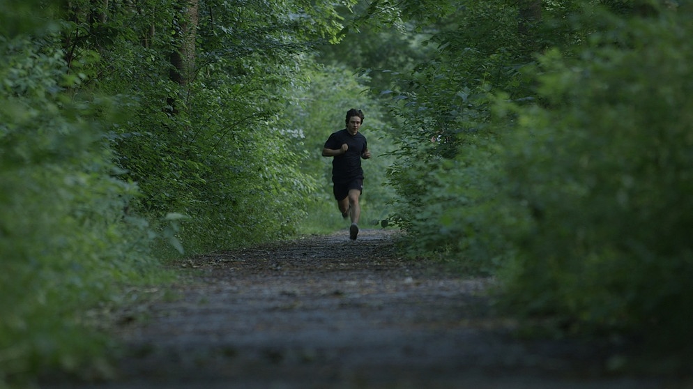 Student Roman, Protagonist in Folge 7 der Reportagereihe UMZUG!, joggt durch ein Waldstück. | Bildquelle: BR