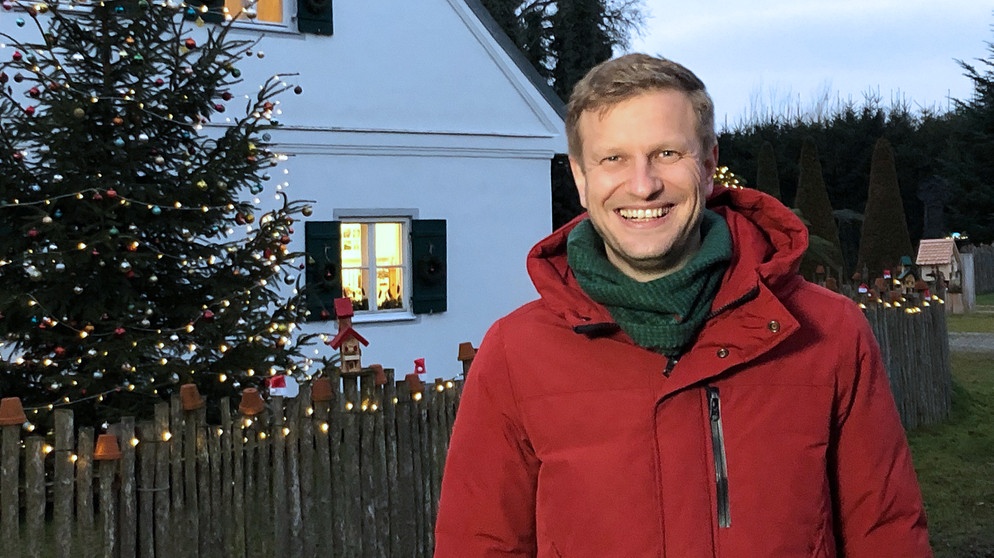 Moderator Florian Kienast vor weihnachtlich beleuchtetem Haus | Bildquelle: BR