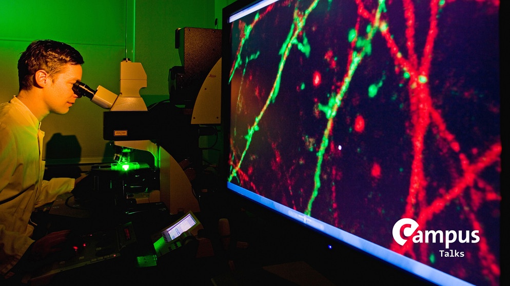 Berlin, Charite, Exzellenzcluster NeuroCure, Hirnforschung, Wissenschaftler untersucht Nervenzellen an einem Fluoreszenzmikroskop. Neurowissenschaftler forschen hier an neurologischen Leiden, wie Alzheimer oder Schlaganfall. Foto mit Campus Logo | Bildquelle: picture alliance / Jürgen Lösel/dpa-Zentralbild/ZB | Jürgen Lösel