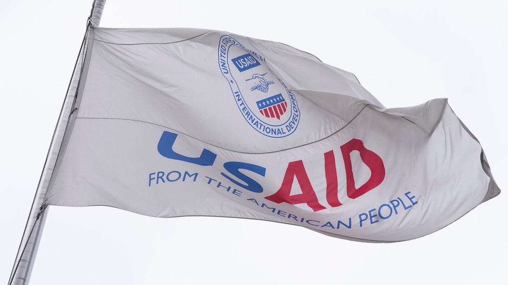 03.02.2025, USA, Washington: Die Flagge der US-Behörde für internationale Entwicklung (USAID) weht vor dem USAID-Büro in Washington. US-Präsident Trump will die US-Entwicklungshilfebehörde abschaffen. Foto: Manuel Balce Ceneta/AP/dpa +++ dpa-Bildfunk +++ | Bildquelle: dpa-Bildfunk/Manuel Balce Ceneta