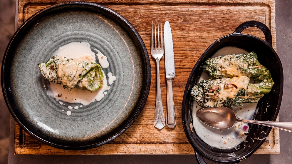 Klassische Rinderrouladen mit Maronenpüree und Rotkrautsalat sind die Leibspeise von Molekularwissenschaftlerin und Food-Bloggerin Tina Kollmann aus Nürnberg. Vroni kombiniert die Aromen auf ihre eigene Art: Sie zaubert eine herzhafte Pastete mit Maronen-Kaninchen-Füllung. Als Beilage gibt es einen Chicoree-Salat. Die Roulade interpretiert Vroni vegetarisch: Als Krautwickerl, gefüllt mit nussigem, fränkischem Grünkern, mit Käse überbacken und serviert mit einer sahnigen Soße (im Bild). | Bildquelle: BR/Sebastian Fery