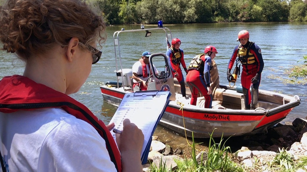 Die Leiterin der Volkacher Wasserwacht Sylvia Voit beurteilt die gespielte Rettungsaktion der angehenden Wasserretter. | Bildquelle: BR/Tom Mandl