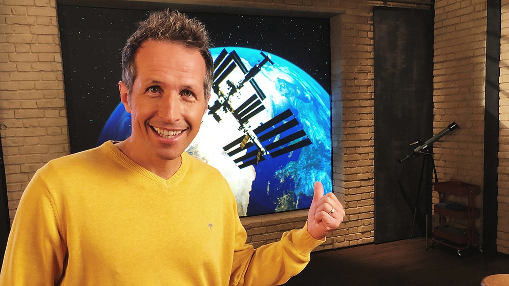 "Gut zu wissen"-Moderator Willi Weitzel zeigt im Hintergrund auf ein Bild mit der Internationalen Raumstation ISS. Matthias Maurer startet zu seiner Mission.  | Bildquelle: BR/Gut zu wissen
