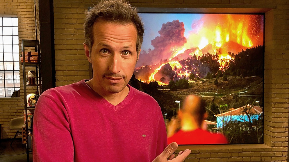 "Gut zu wissen"-Moderator Willi Weitzel im Hintergrund Bild vom Vulkanausbruch auf La Palma. | Bildquelle: BR/Gut zu wissen