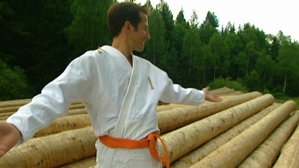 Wer vermöbelt den Wald? / Willi Weitzel im Karate-Anzug vor gefällten Bäumen für Möbelholz | Bildquelle: BR 