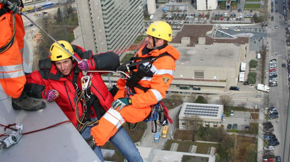 Vorfahrt für die Feuerwehr! / Willi Weitzel (links) mit dem Höhenretter Berni von der Berufsfeuerwehr München am Hypobankgebäude in München. | Bildquelle: BR/megaherz