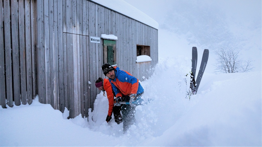 Zwei Skibergsteiger schaufeln den Eingang des Winterraums frei | Bildquelle: BR/Thomas März