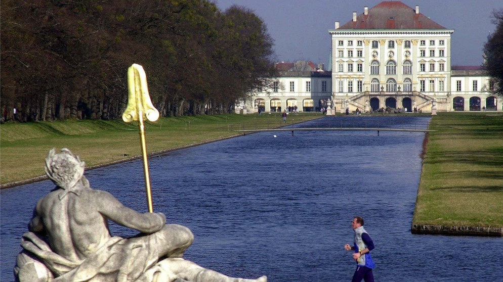Ein Jogger läuft am Neptunbrunnen im Park von Schloss Nymphenburg vorbei. | Bildquelle: picture-alliance / dpa | Matthias Schrader