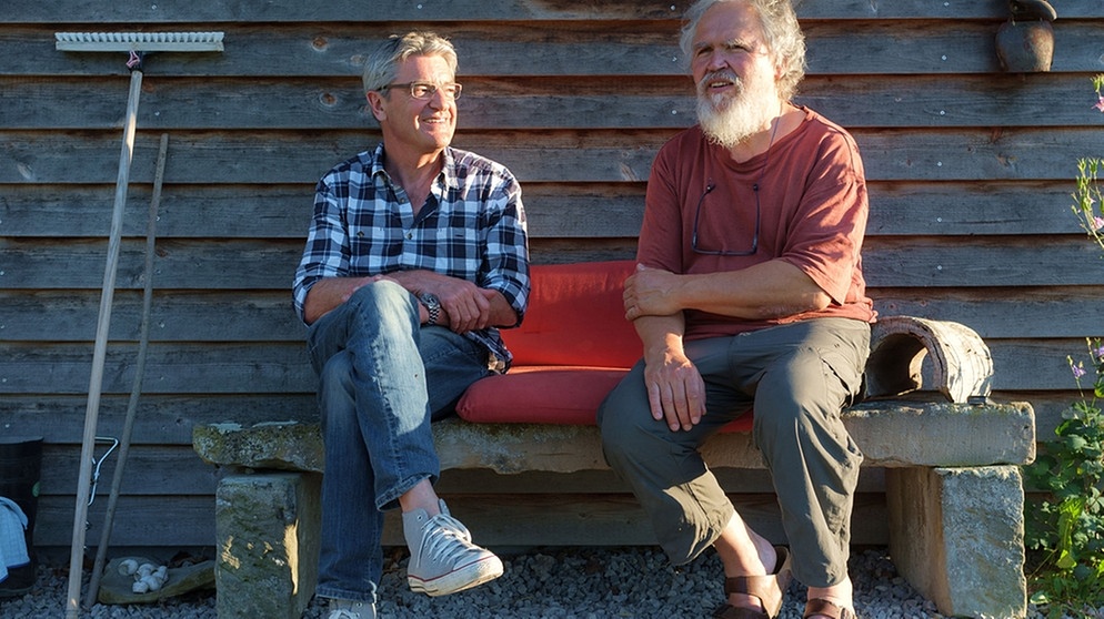 Franz Gernstl und Roqueforts-Produzent Norbert Fischer sitzen auf einer Gartenbank | Bildquelle: megaherz