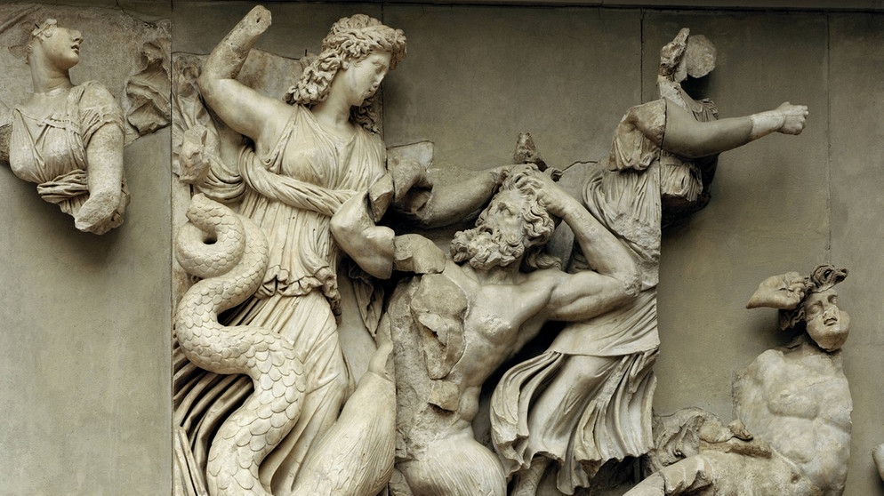 Pergamonaltar: Griechische Plastik, hellenistisch, um 180 v.Chr. Zeus-Altar von Pergamon. - Kampf der Götter und Giganten: Zwei Moiren kämpfen mit Schwert und Lanze zwei Giganten nieder. - Nordfries, Ausschnitt. | Bildquelle: picture-alliance/dpa