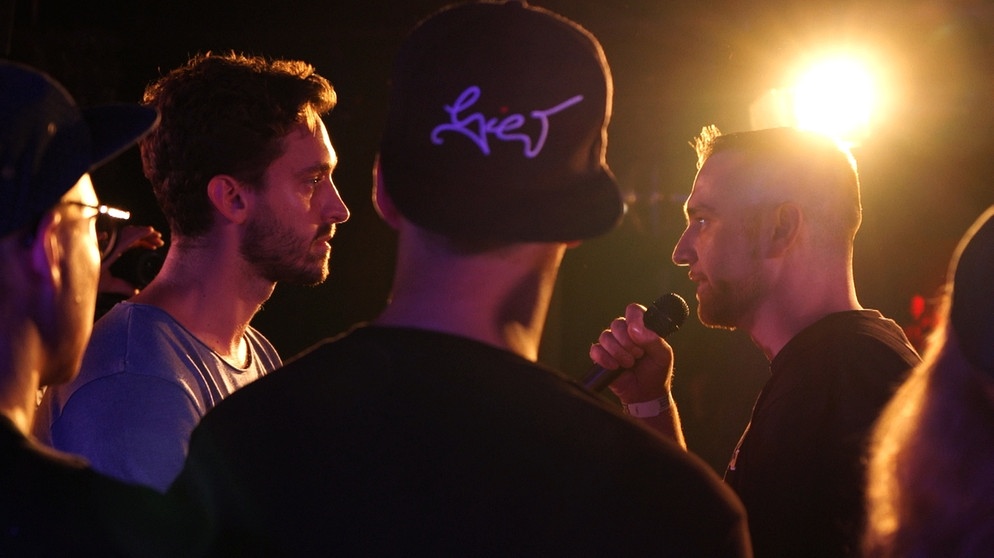 Battle-Rap ist das Duell der Neuzeit – penibel vorbereitet und auf den Punkt formuliert. Worte müssen Gegner treffen, müssen wehtun, aber mit Witz und Verstand verpackt sein. Die Besten ihrer Szene treffen sich zum Saisonfinale in Berlin. Darunter auch Newcomer Kato, der im Mainmatch seine Sprachgewalt gegenüber Gegner Bong Teggy beweisen muss. | Bildquelle: BR