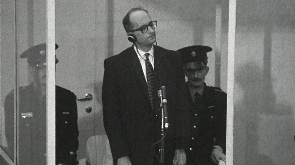 Adolf Eichmann (Mitte) im kugelsicheren Glaskasten mit zwei Polizisten. | Bildquelle: BR