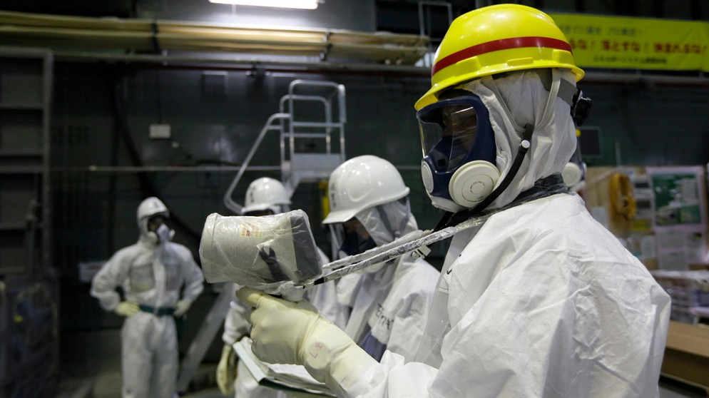 Menschen in Schutzkleidung führen Strahlungsmessungen im Atomkraftwerk Fukushima durch, Japan | Bildquelle: picture alliance / AP Images | Kimimasa Mayama